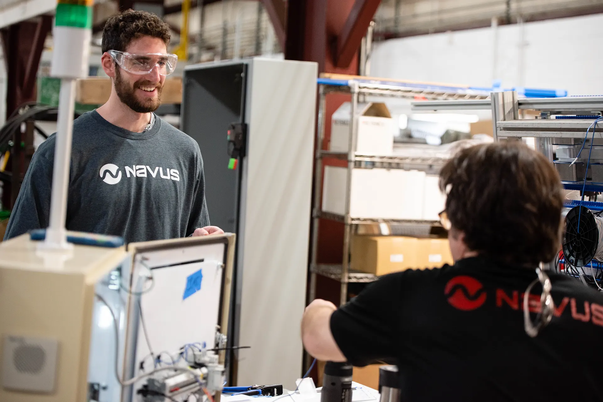 Two people talking in an industrial workspace.