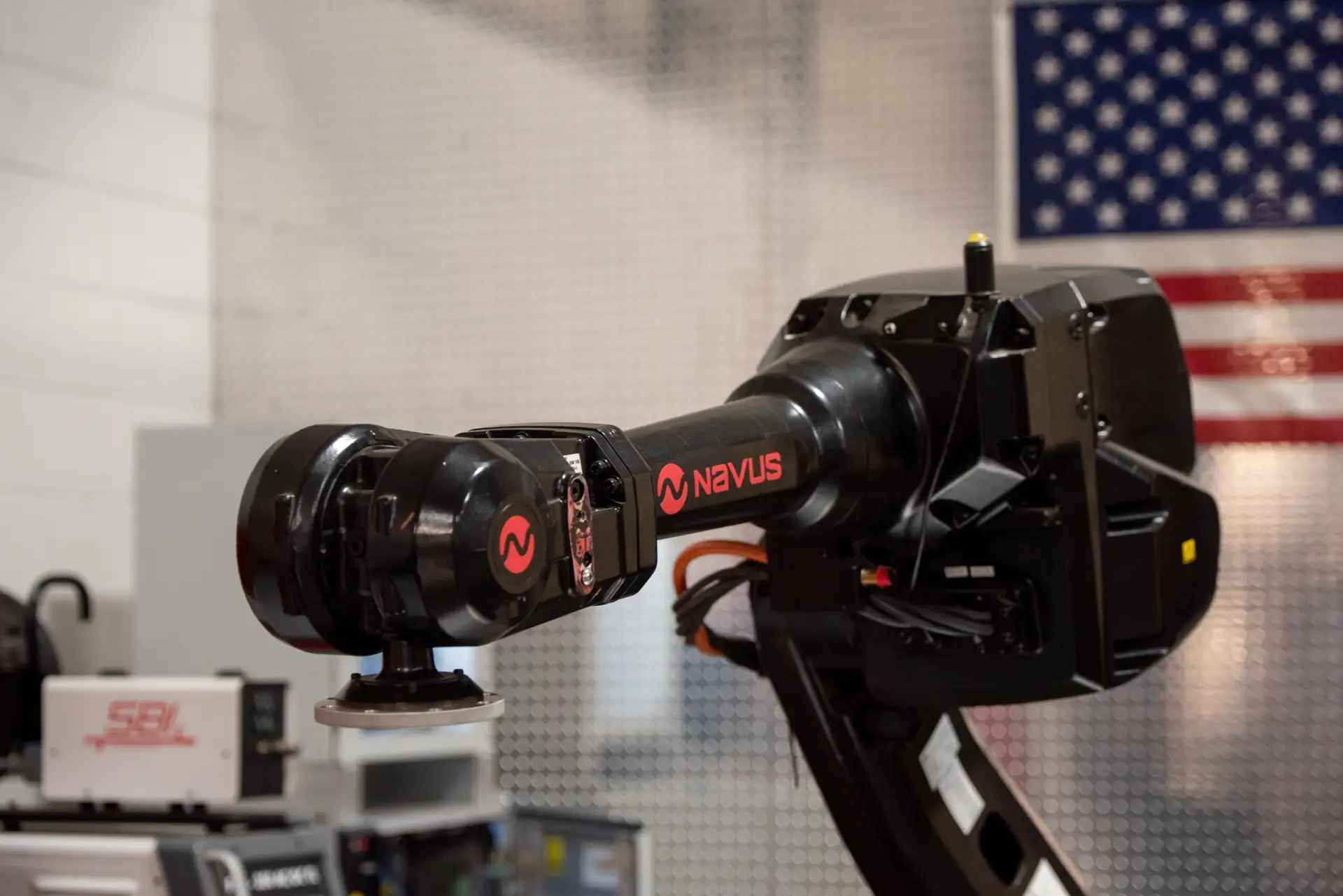 Robotic arm in industrial setting with flag.